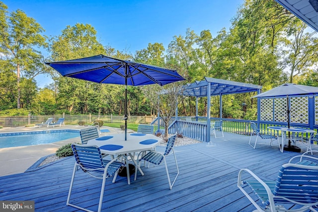 deck featuring a fenced in pool and a pergola