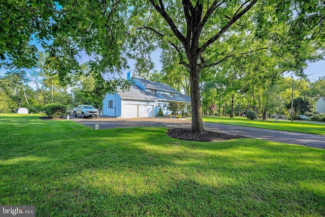 view of front of home with a garage and a front lawn