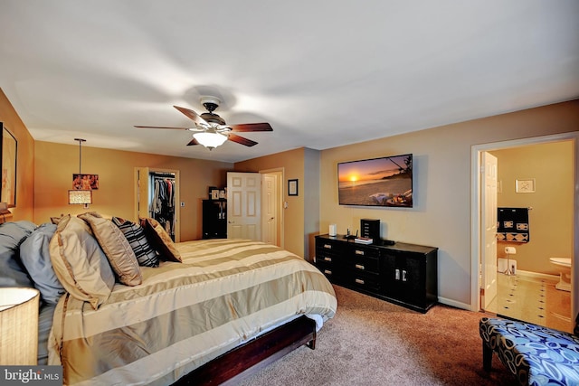 carpeted bedroom featuring a closet, connected bathroom, ceiling fan, and a walk in closet