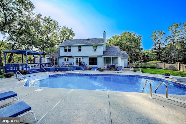 view of swimming pool featuring a wooden deck and a patio