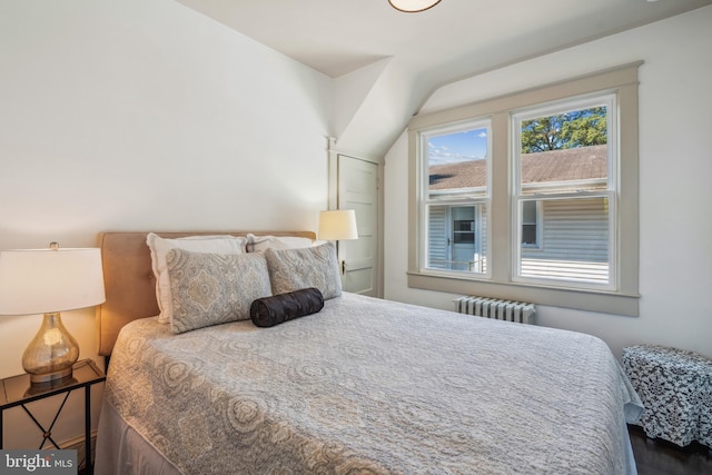 bedroom featuring radiator heating unit and dark hardwood / wood-style floors