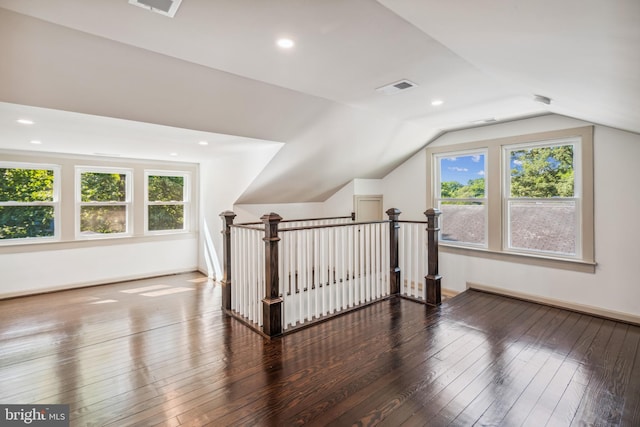 bonus room with a wealth of natural light, vaulted ceiling, and hardwood / wood-style floors