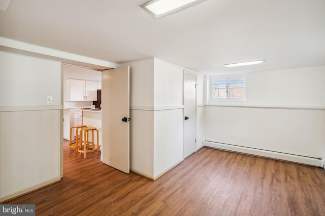 spare room with a baseboard radiator and wood-type flooring