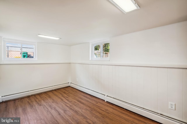 spare room featuring a baseboard heating unit and hardwood / wood-style floors