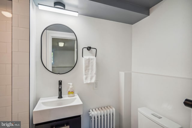 bathroom featuring vanity, toilet, and radiator heating unit