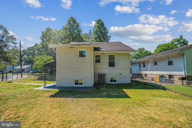 back of property with central AC unit and a yard