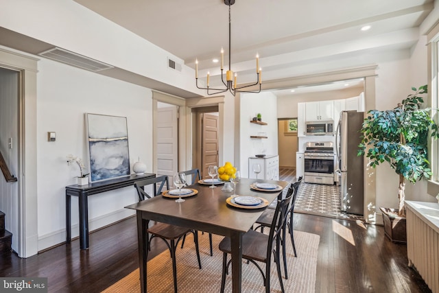 dining space featuring dark wood-type flooring and a chandelier