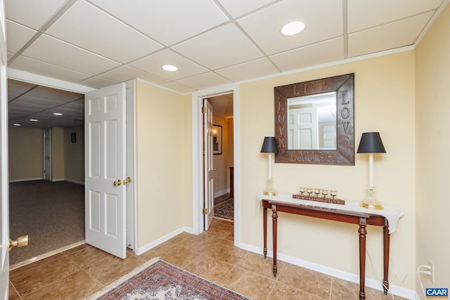 hallway with light tile patterned floors and a drop ceiling