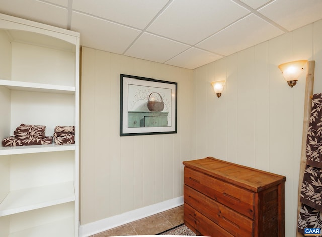 interior space with a paneled ceiling and tile patterned floors