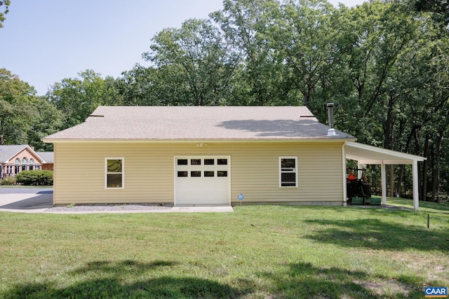 back of property featuring a lawn and a garage