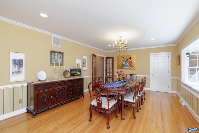 dining room featuring crown molding, light hardwood / wood-style flooring, and a chandelier