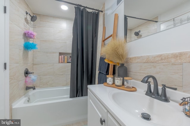 bathroom with tile walls, vanity, and shower / bath combo