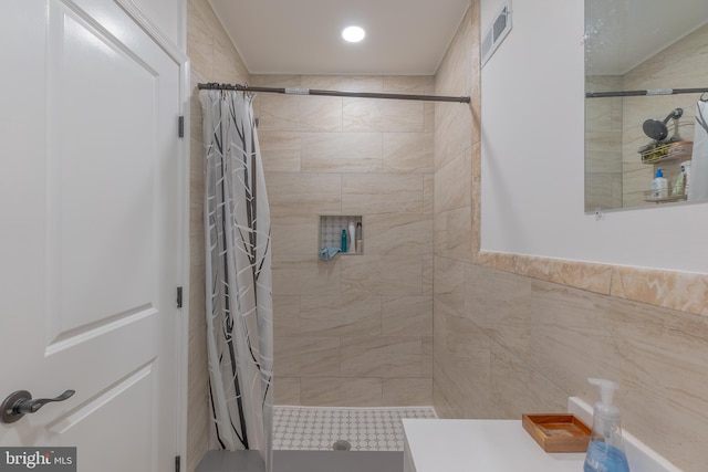 bathroom featuring curtained shower and tile walls