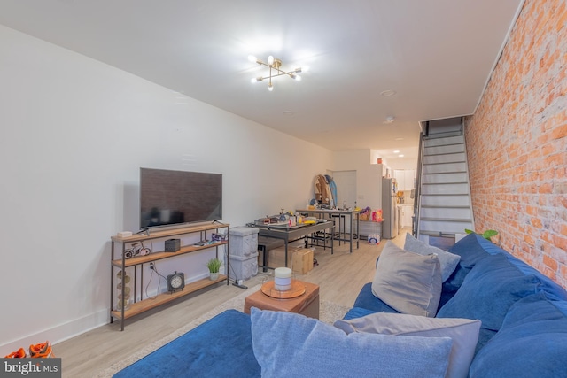 living room featuring brick wall and light hardwood / wood-style floors