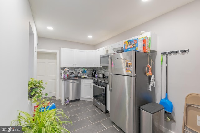 kitchen featuring backsplash, appliances with stainless steel finishes, and white cabinets