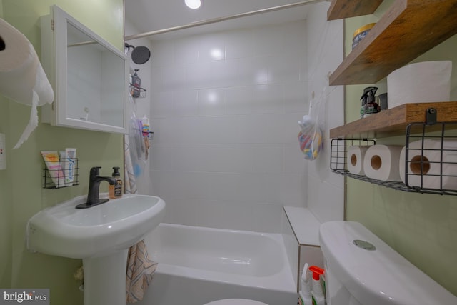 bathroom with toilet and tiled shower / bath combo