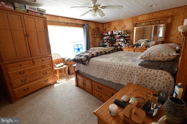 bedroom with light carpet, wood ceiling, wood walls, and ceiling fan