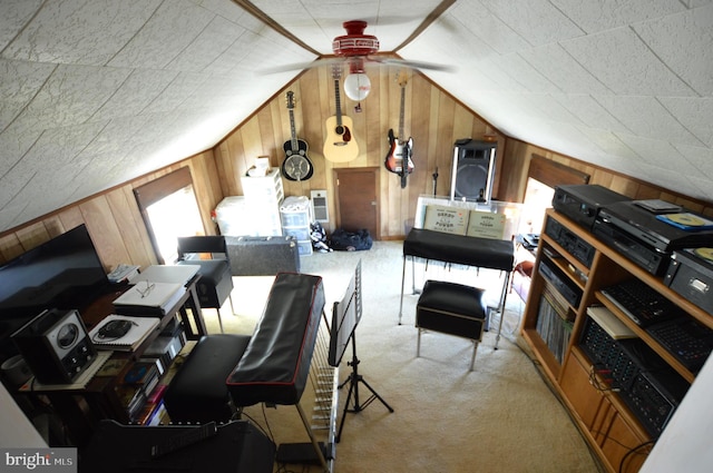 additional living space with light colored carpet, ceiling fan, wood walls, and vaulted ceiling