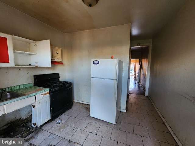 kitchen with white cabinets, white refrigerator, sink, and black range with gas cooktop