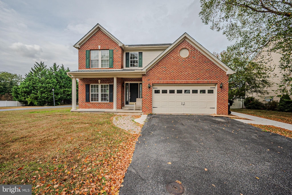 15 Houston St, Dover, DE 19901 - traditional home featuring a front yard, brick siding, an attached garage, and driveway
