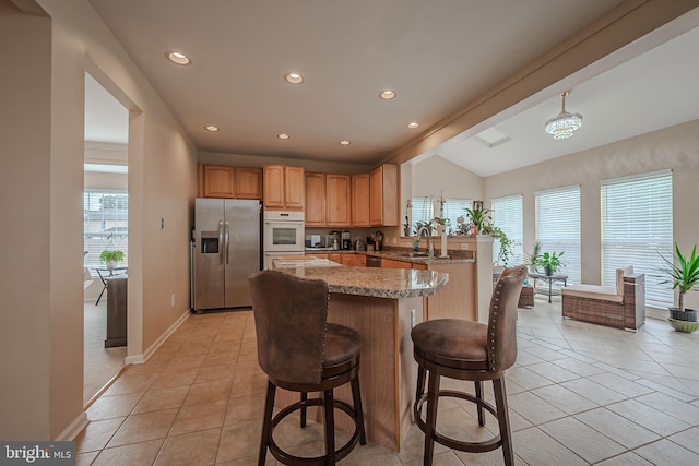 kitchen with white oven, lofted ceiling, stainless steel fridge with ice dispenser, and a healthy amount of sunlight