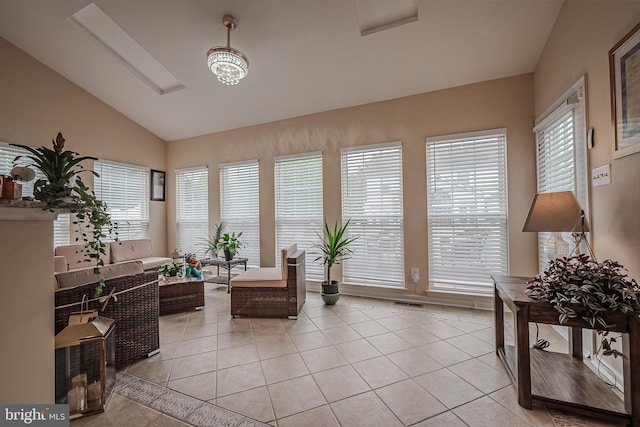 living area featuring a notable chandelier, vaulted ceiling, and light tile patterned floors