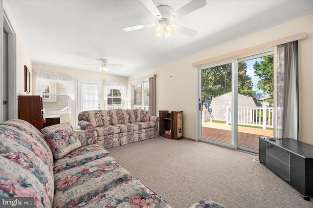 carpeted living room featuring a wealth of natural light and ceiling fan