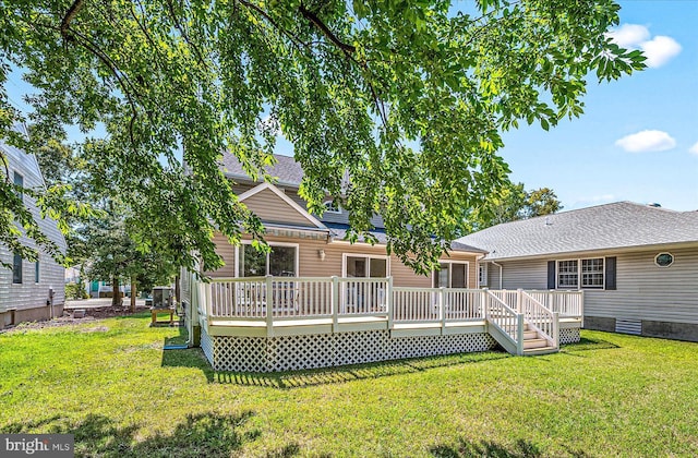 back of property with a lawn and a wooden deck