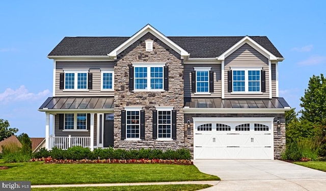 view of front of home with roof with shingles, a standing seam roof, a front lawn, concrete driveway, and metal roof