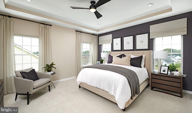 carpeted bedroom with ceiling fan, a raised ceiling, and crown molding