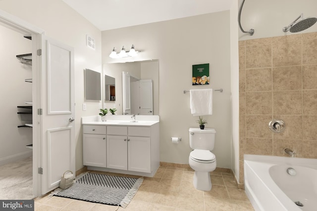 full bathroom with tile patterned flooring, tiled shower / bath, vanity, and toilet