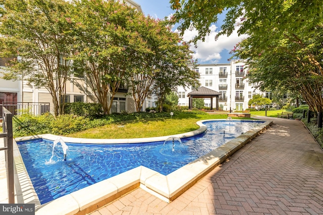 view of swimming pool with a gazebo and a yard