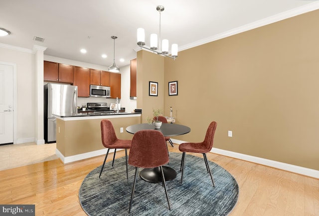 dining space with a notable chandelier, light wood-type flooring, and crown molding