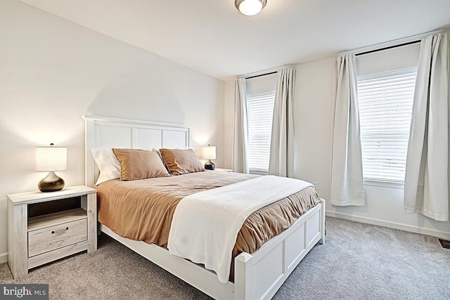 bedroom with baseboards and light carpet