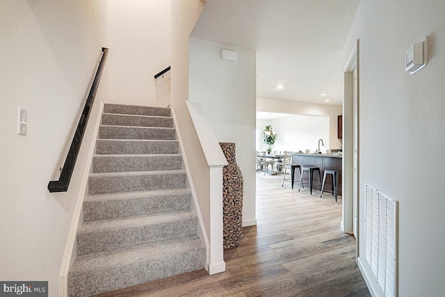 stairs with visible vents, recessed lighting, baseboards, and wood finished floors