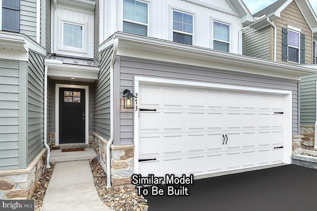 property entrance with an attached garage and stone siding