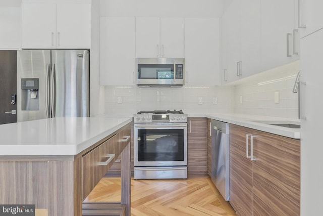 kitchen with appliances with stainless steel finishes, tasteful backsplash, white cabinets, and light parquet floors