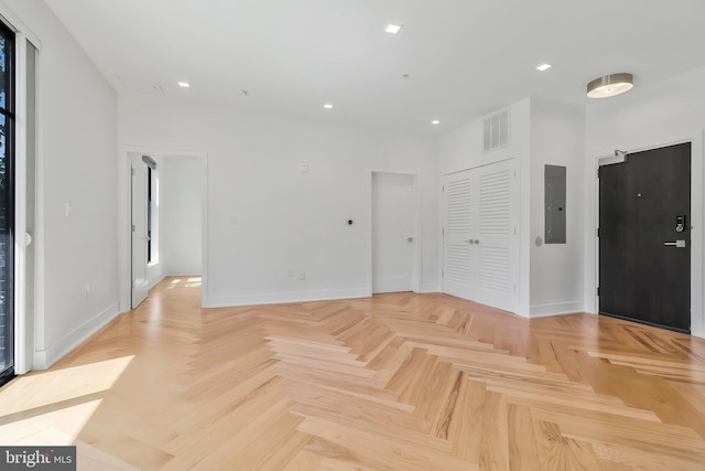 empty room featuring light parquet flooring and electric panel