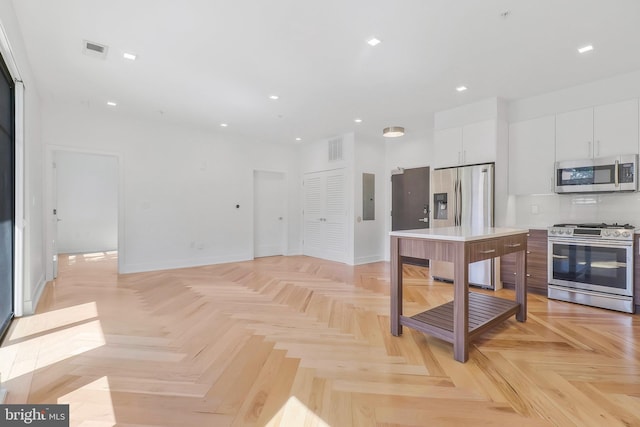 kitchen featuring electric panel, a center island, stainless steel appliances, and light parquet flooring