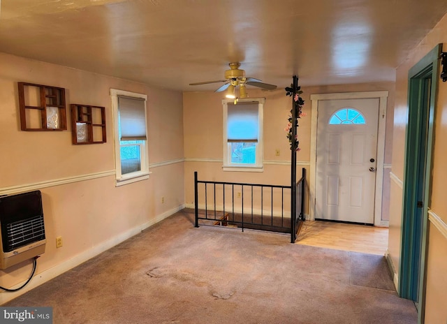 carpeted entrance foyer with baseboards, heating unit, and ceiling fan