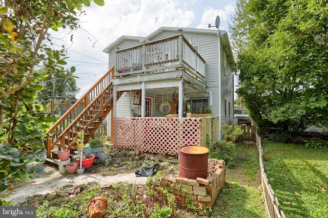 back of property featuring a lawn and a balcony