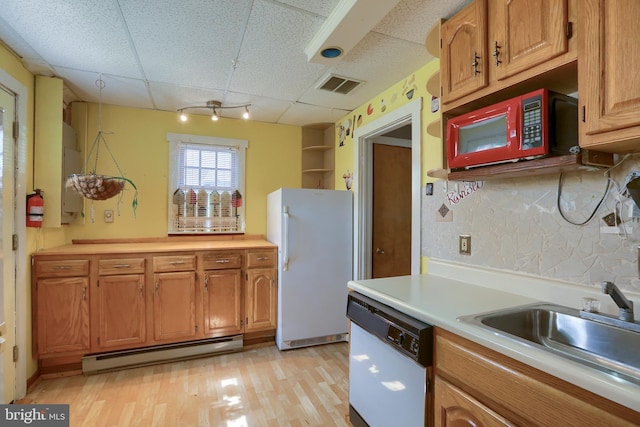 kitchen featuring white appliances, visible vents, a sink, light countertops, and baseboard heating