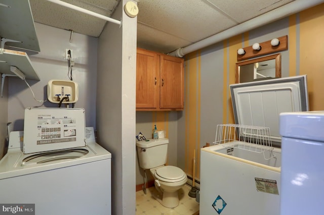 washroom with baseboards, washer / dryer, and laundry area