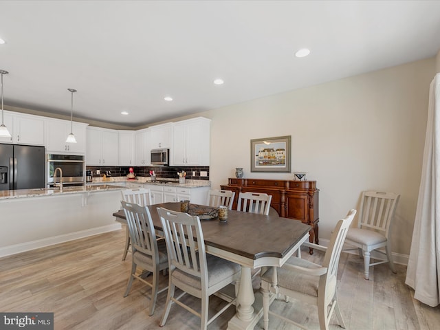 dining space featuring light hardwood / wood-style flooring and sink