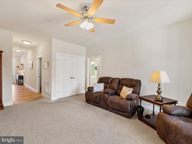 carpeted living room with ceiling fan