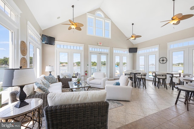 living room featuring french doors, light tile patterned floors, and high vaulted ceiling