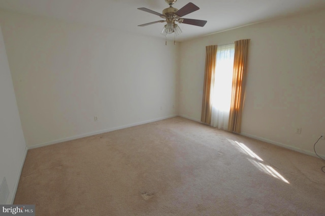 carpeted spare room featuring ceiling fan