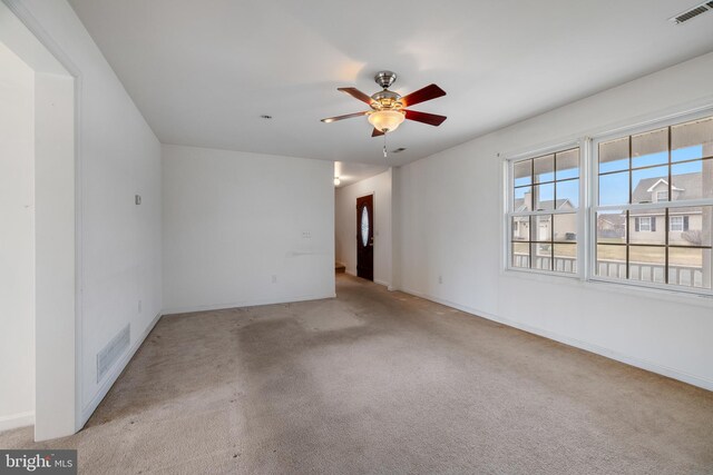 empty room featuring ceiling fan and light carpet