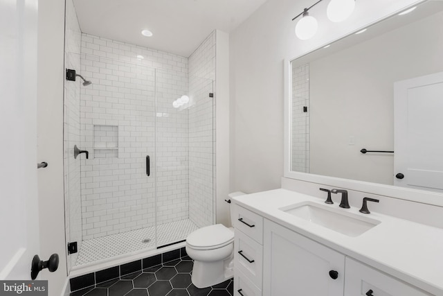 bathroom featuring tile patterned flooring, vanity, toilet, and an enclosed shower