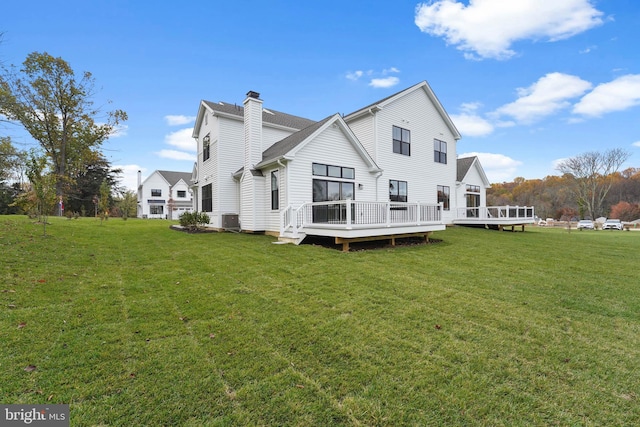 back of property featuring cooling unit, a lawn, and a wooden deck